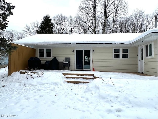 view of snow covered rear of property