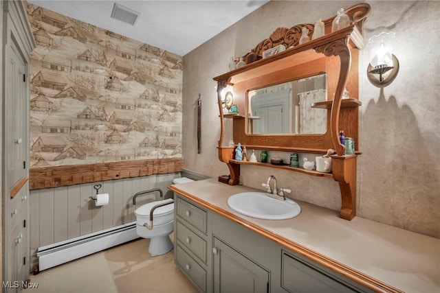 bathroom featuring vanity, a baseboard heating unit, and toilet