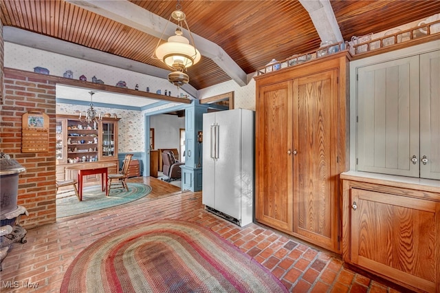 kitchen featuring hanging light fixtures, beamed ceiling, high end white fridge, and wooden ceiling