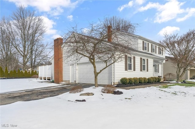 snow covered property with a garage