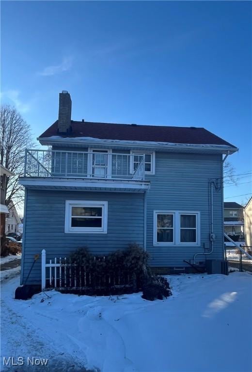 snow covered property featuring a balcony