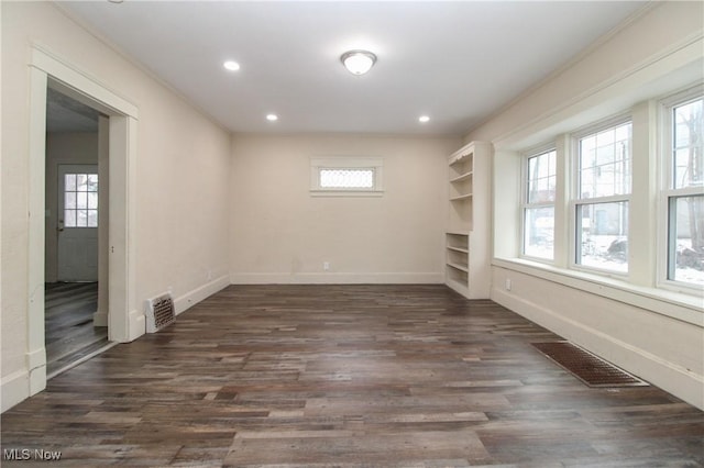 unfurnished room featuring ornamental molding and dark hardwood / wood-style flooring