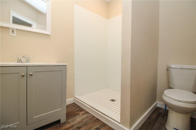 bathroom with walk in shower, vanity, toilet, and hardwood / wood-style flooring