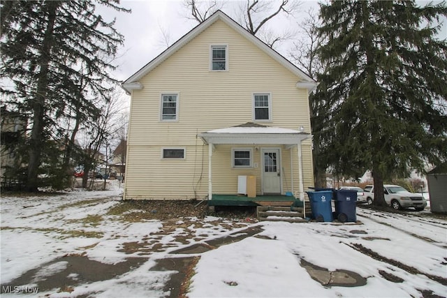 view of snow covered rear of property