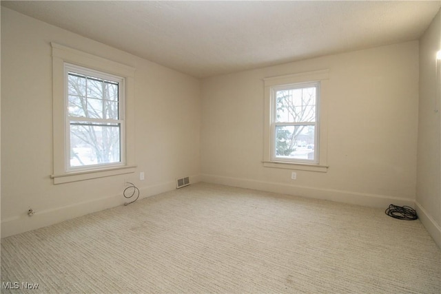 spare room with carpet floors and plenty of natural light