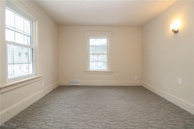 carpeted spare room featuring plenty of natural light