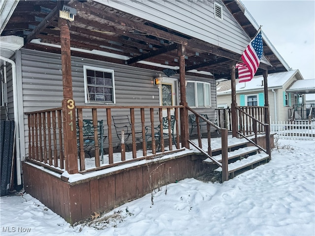 snow covered deck featuring fence