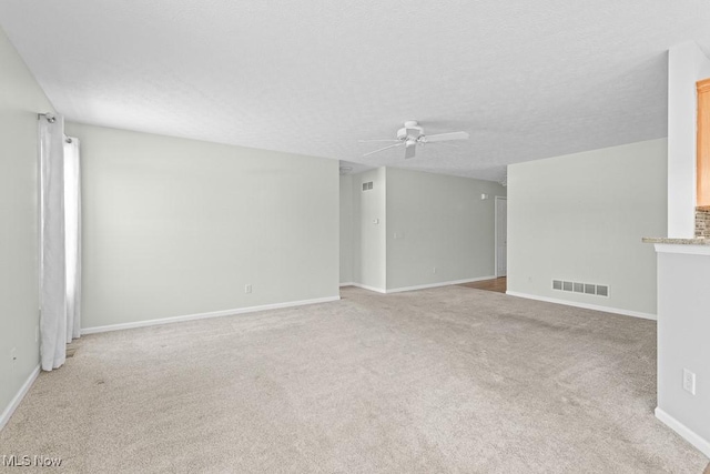 carpeted spare room with a textured ceiling and ceiling fan