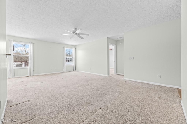 carpeted empty room with ceiling fan and a textured ceiling