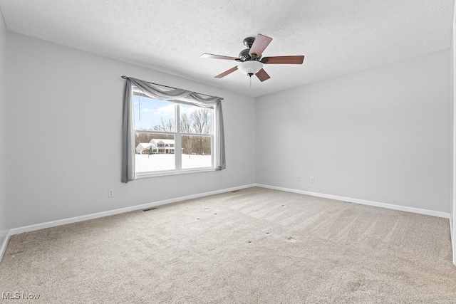 empty room featuring ceiling fan, carpet, and a textured ceiling