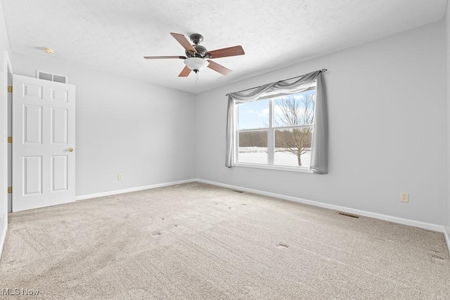 spare room with ceiling fan, carpet flooring, and a textured ceiling