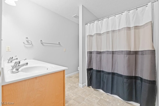 bathroom featuring vanity, a shower with shower curtain, a textured ceiling, and toilet