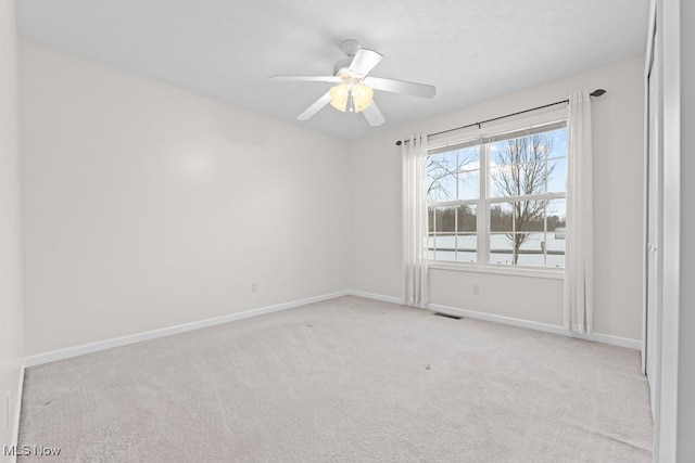 unfurnished room with ceiling fan and light carpet