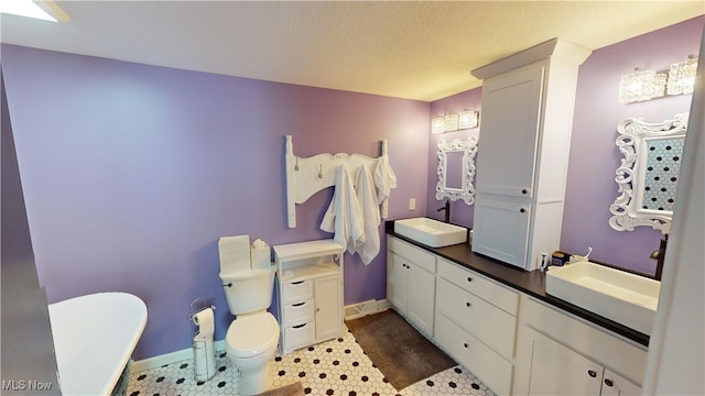 bathroom with vanity, tile patterned floors, a textured ceiling, and toilet