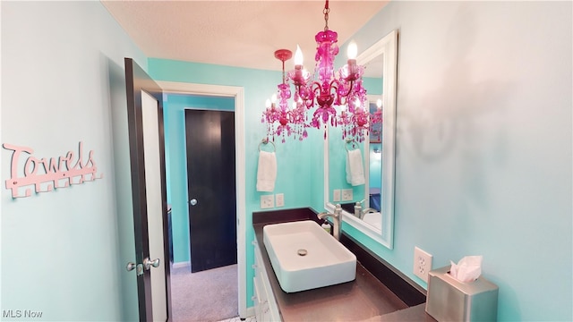 bathroom featuring sink and a chandelier