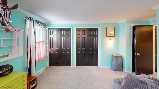 bedroom with ornamental molding, carpet, and two closets