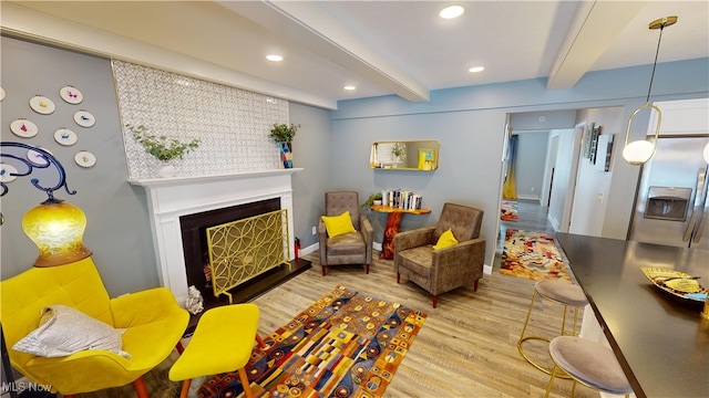 sitting room with beamed ceiling and light wood-type flooring