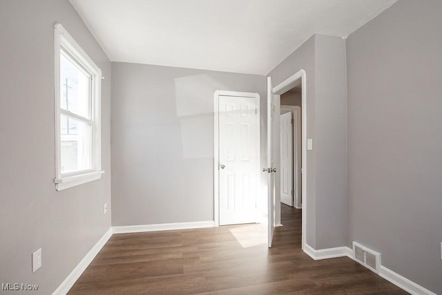 spare room featuring dark wood-type flooring