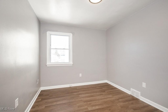 spare room with dark wood-type flooring