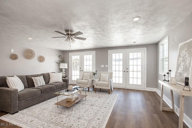 living room with a textured ceiling, dark hardwood / wood-style flooring, and french doors