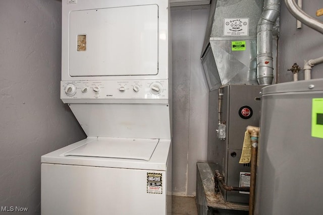 washroom featuring stacked washer / drying machine and water heater