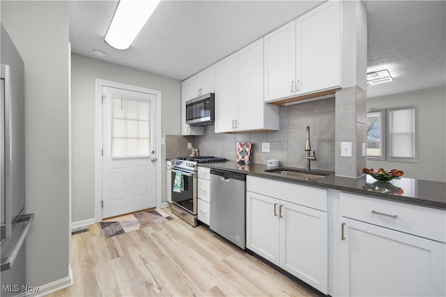 kitchen featuring white cabinetry, stainless steel appliances, sink, and decorative backsplash