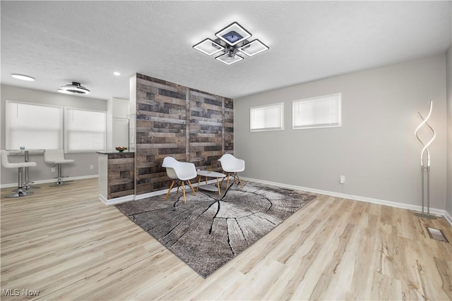 living area with light hardwood / wood-style floors and a textured ceiling