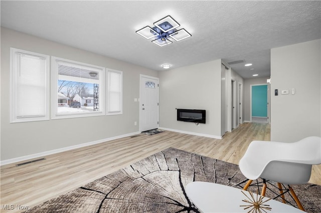 living room featuring a textured ceiling and light wood-type flooring