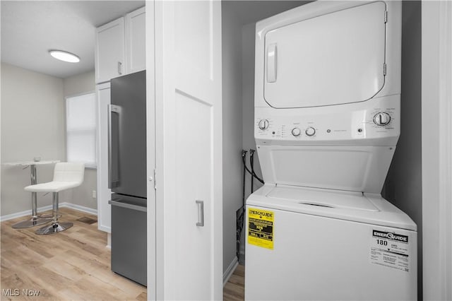 washroom featuring light wood-type flooring and stacked washing maching and dryer