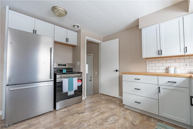 kitchen with backsplash, stainless steel appliances, butcher block countertops, and white cabinets