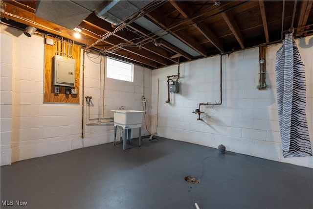 basement featuring electric panel and sink