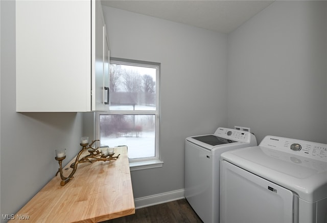 laundry area featuring cabinets, dark hardwood / wood-style floors, and washer and clothes dryer