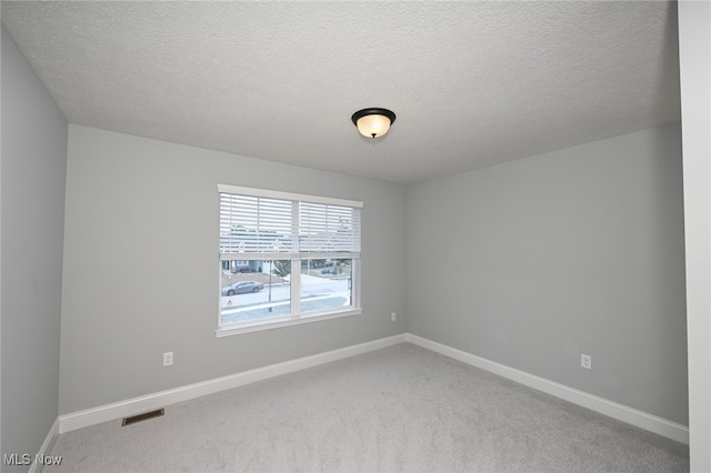 carpeted spare room featuring a textured ceiling