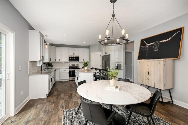 dining area with dark hardwood / wood-style flooring, sink, and an inviting chandelier