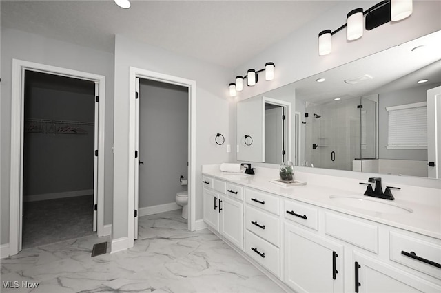 bathroom featuring vanity, toilet, and a shower with door