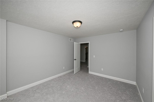 carpeted spare room with a textured ceiling