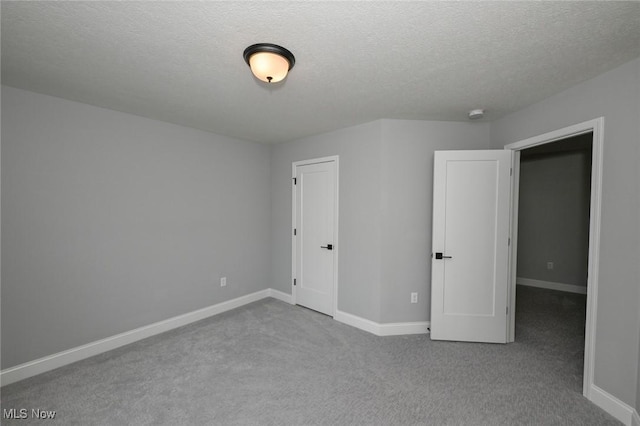 unfurnished bedroom featuring light carpet and a textured ceiling