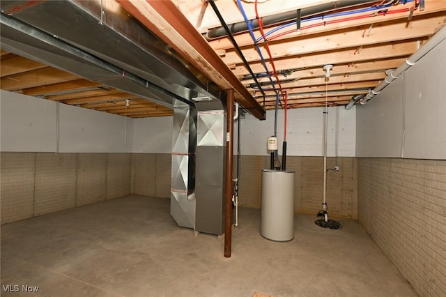 basement with brick wall, heating unit, and gas water heater