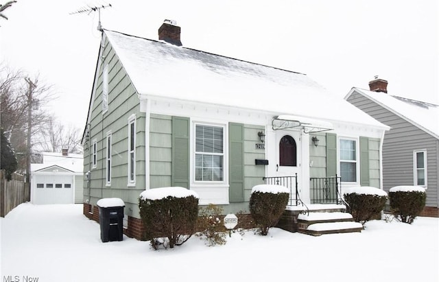 view of front of property with a garage and an outdoor structure