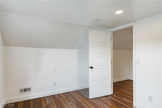 bonus room with dark wood-type flooring and vaulted ceiling