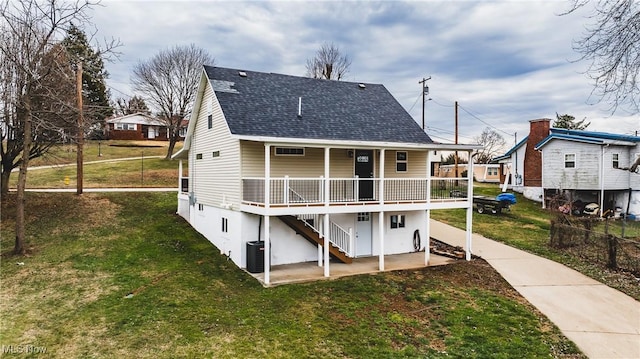 rear view of property featuring a porch, central air condition unit, and a lawn