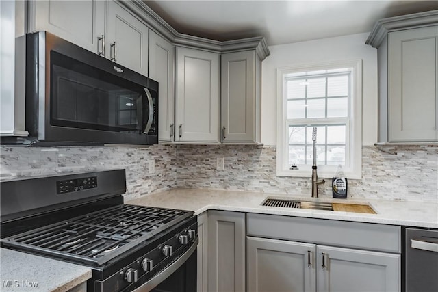 kitchen with decorative backsplash, gray cabinets, and appliances with stainless steel finishes