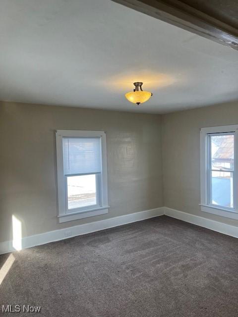 unfurnished room with dark carpet