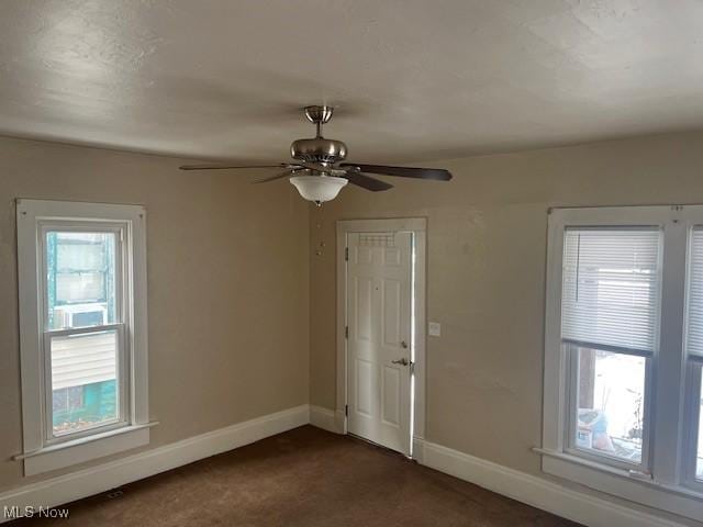 carpeted spare room featuring ceiling fan