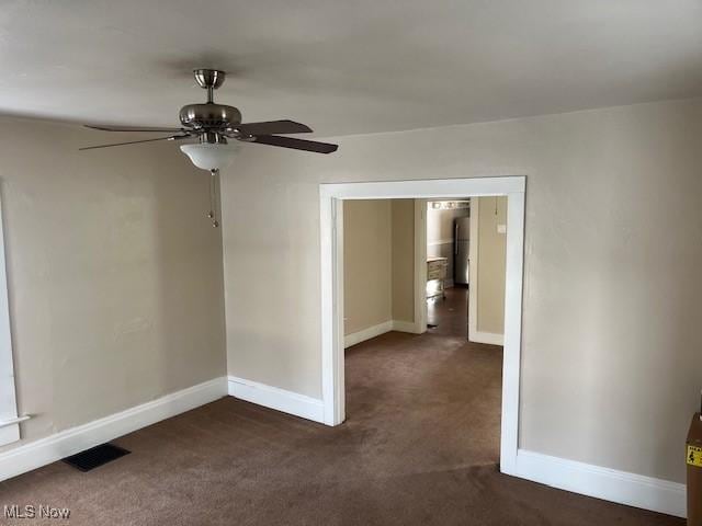 spare room with dark colored carpet