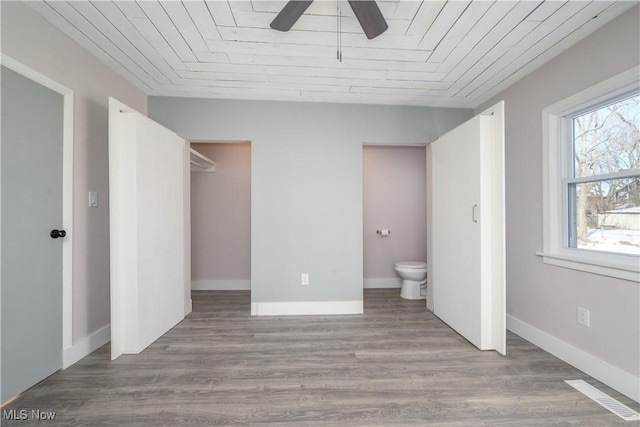 unfurnished bedroom featuring hardwood / wood-style flooring, ceiling fan, connected bathroom, and wooden ceiling