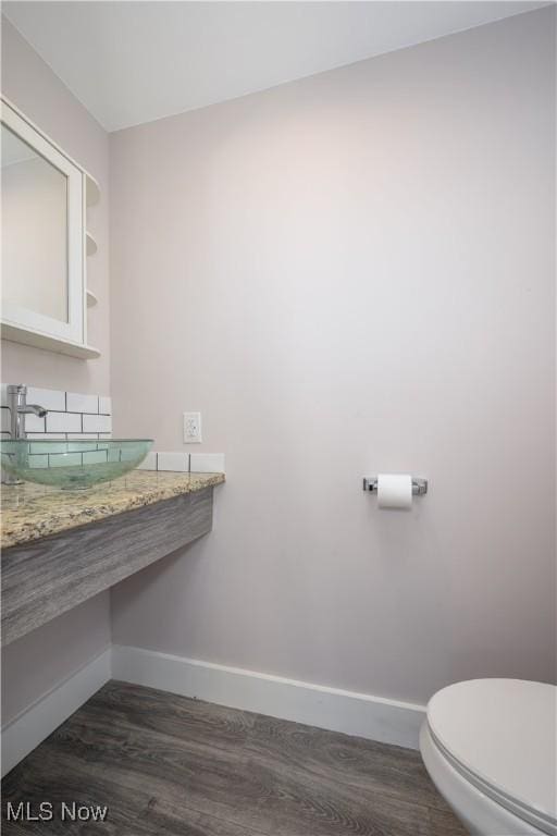 bathroom with sink, hardwood / wood-style flooring, and toilet