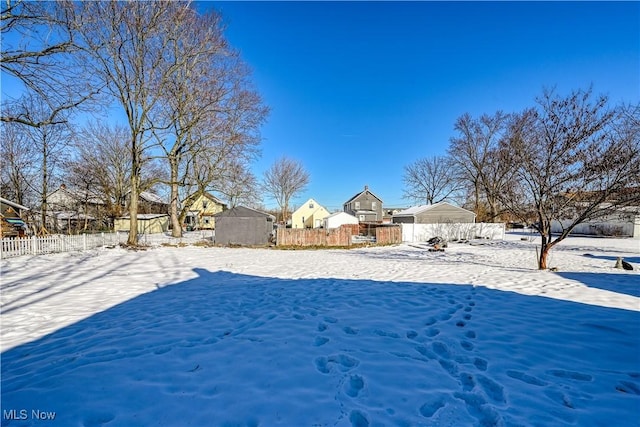 yard layered in snow with a storage shed