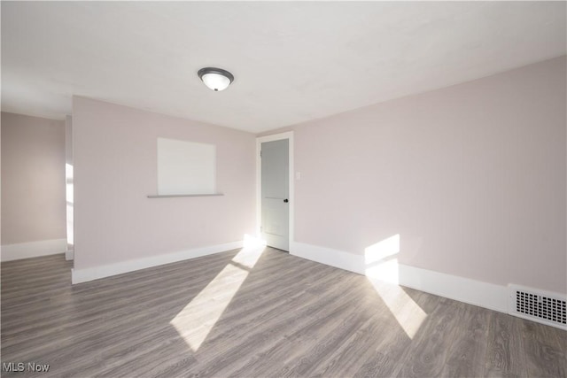 unfurnished room with dark hardwood / wood-style flooring