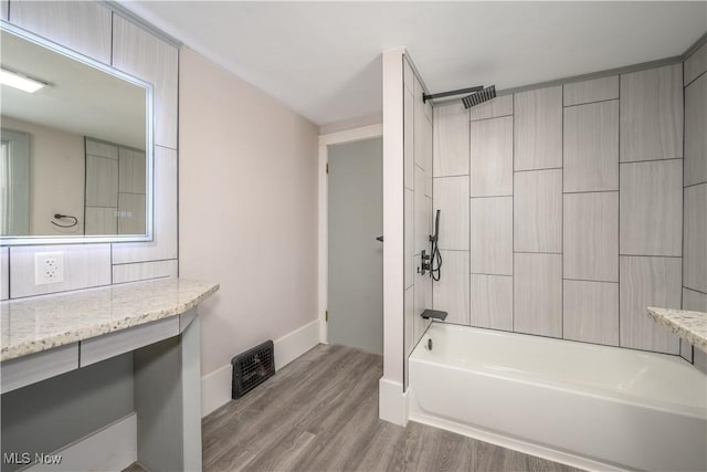 bathroom featuring wood-type flooring, vanity, and shower / bathing tub combination